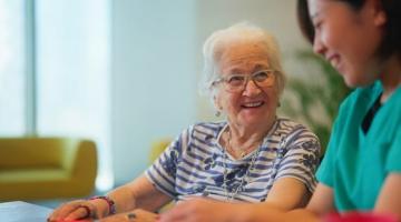 Elderly woman being helped by younger woman