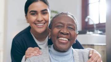 female nurse with hands on shoulders of female patient