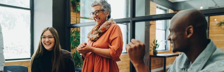 Middle-aged woman laughing with colleagues 