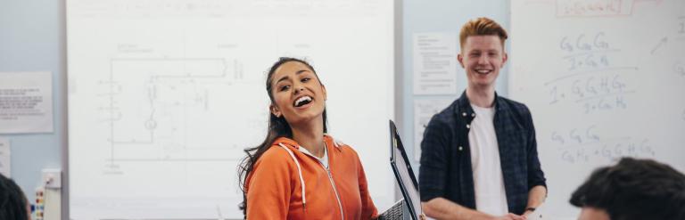 young female student in room with other students